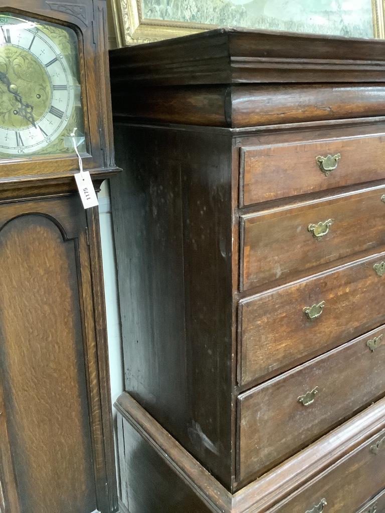An 18th century cross banded oak chest on stand, width 116cm, depth 57cm, height 170cm